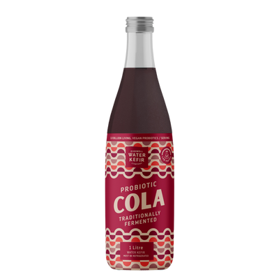 Bottle of probiotic cola with a red label on a white background