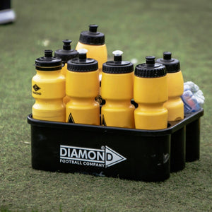 Yellow footballs in a black Diamond Football Company holder on grass