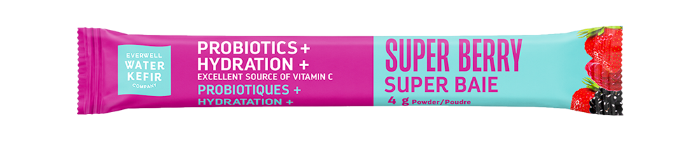 A single-serving powder snack stick of Evewell Water Kefir's 'Super Berry Super Baie' on a plain white background. The packaging features a vibrant pink-to-light-blue gradient with illustrations of strawberries, blackberries, and blueberries.