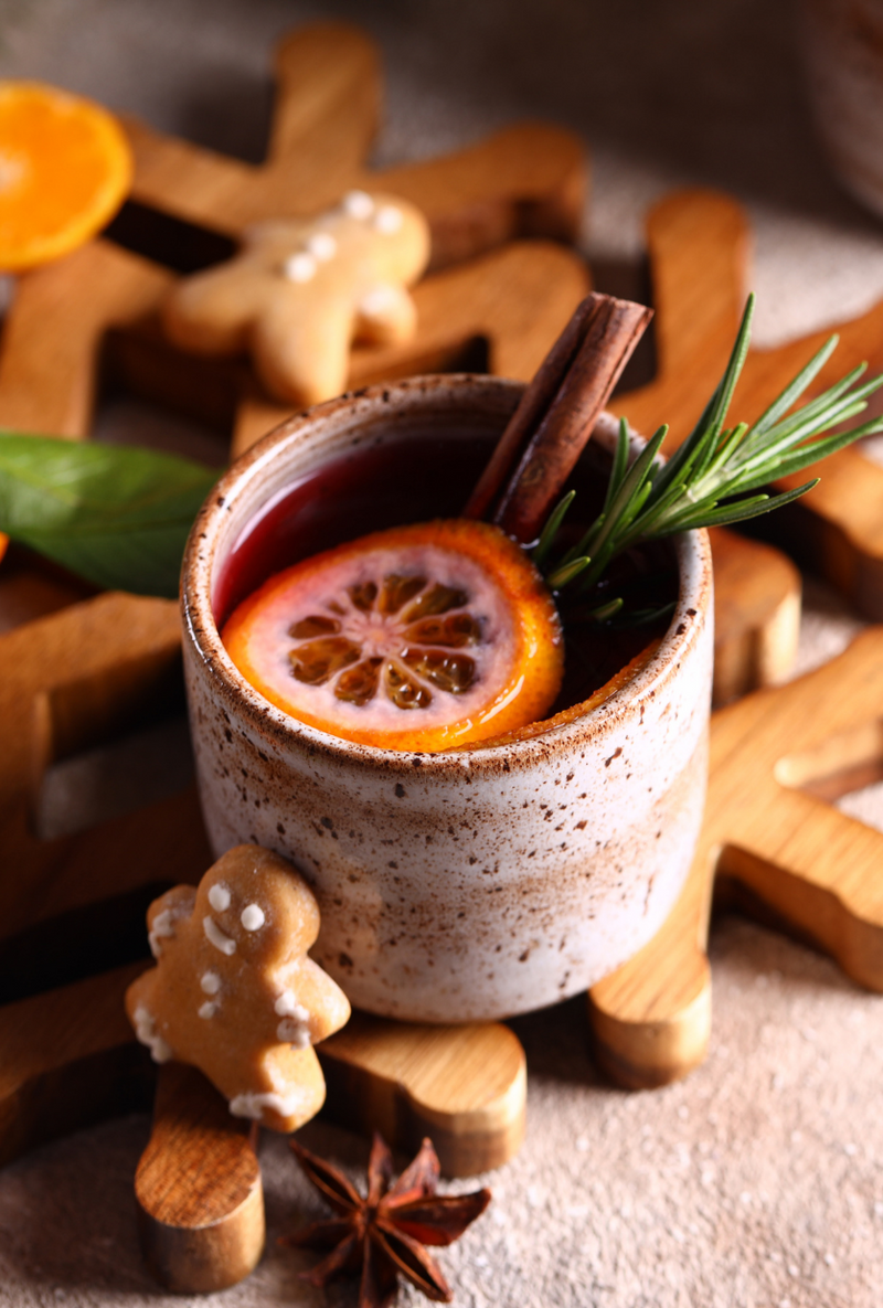 Holiday punch recipe with ingredients and garnishes on a wooden surface, accompanied by a text box with the recipe.