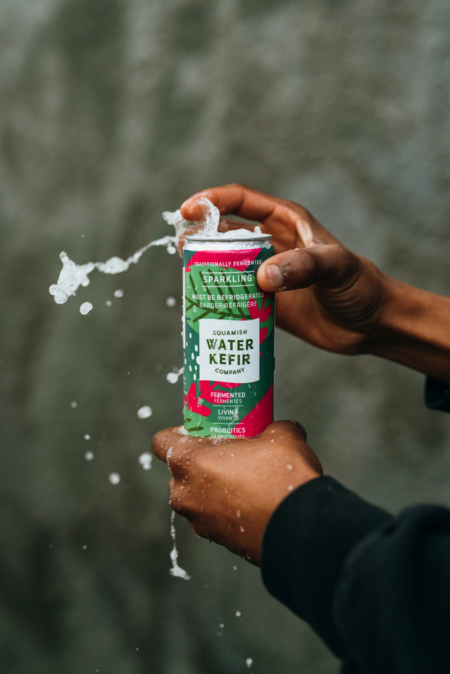 Person holding a can of Water Kefir with a blurred background