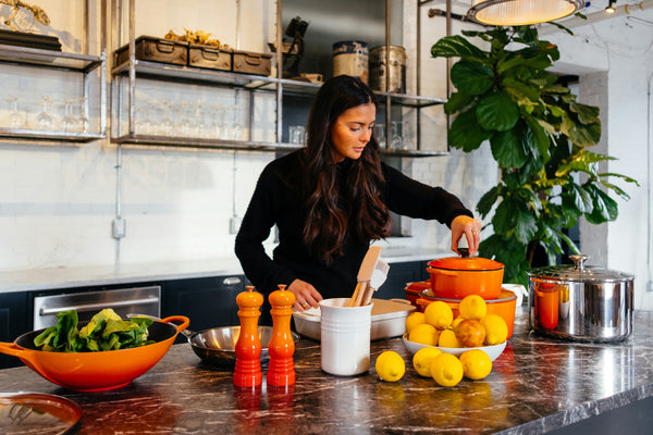 Woman preparing healthy food in a modern kitchen with fresh ingredients and cooking utensils - culinary lifestyle scene